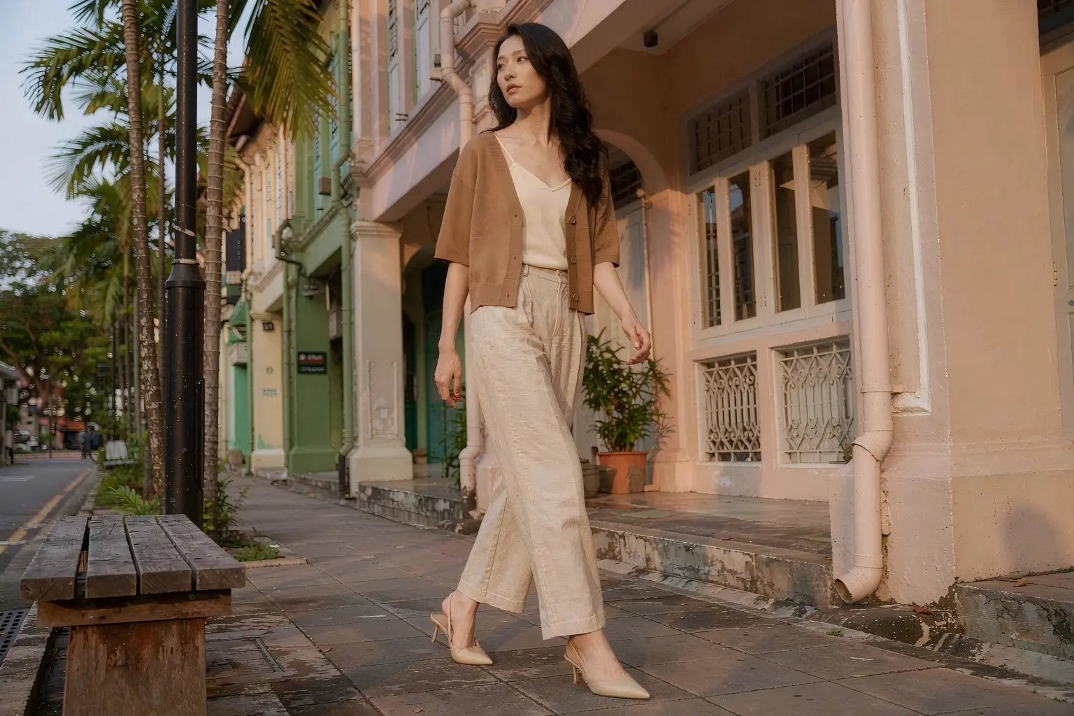 Short-sleeve camel knit cardigan styled on a shophouse sidewalk