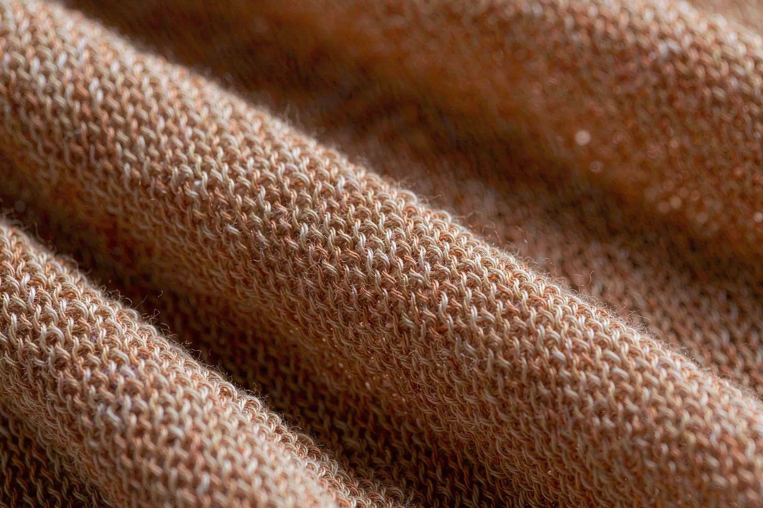 Macro detail of lightweight cotton and linen knit in warm apricot tone with open breathable stitch structure for humid climates